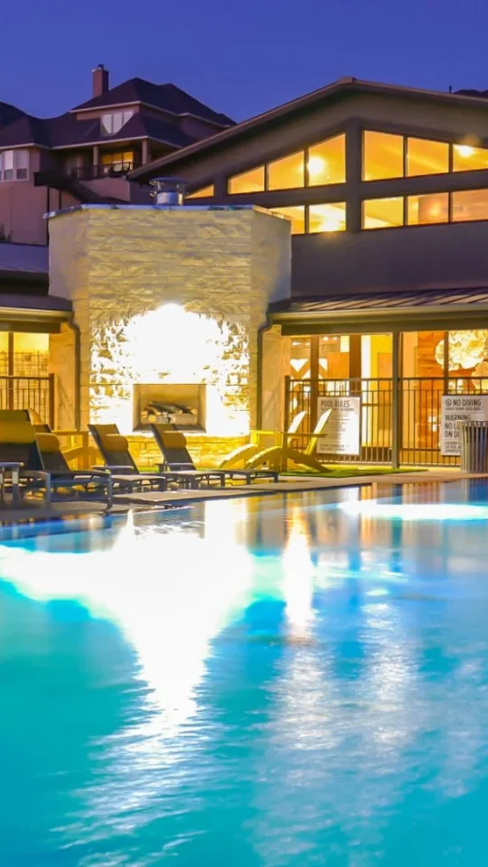a large swimming pool at night with lounge chairs at The  View at Crown Ridge
