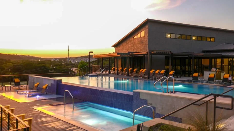 a pool with sun loungers and umbrellas at sunset at The  View at Crown Ridge