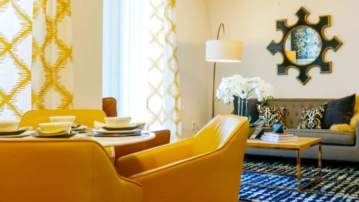 a living room with yellow chairs and a blue table at The  View at Crown Ridge